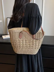 Straw tote bag with brown leather straps and woven pattern for beach or daily use