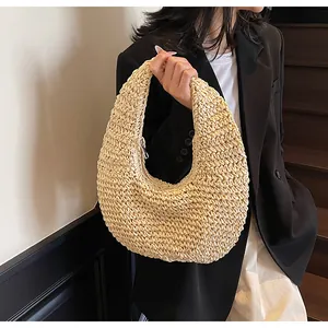 Detail of a beige woven straw hobo bag showing handmade crochet texture and curved design
