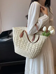 Straw woven beach tote bag with brown leather straps and spacious interior for vacation