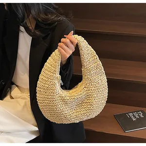 Detailed close-up of crescent woven straw bag with metal zipper and boho texture