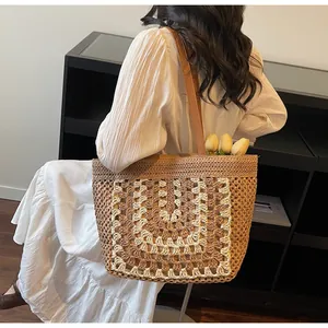 Détail du grand sac cabas en paille avec motif floral au crochet et anses en cuir