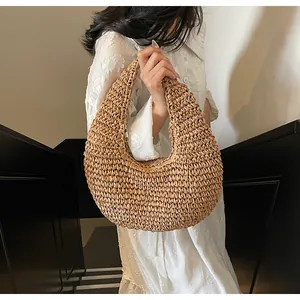 Detail of bohemian hollow straw tote bag showing intricate woven texture and curved handle
