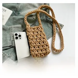 Close-up of khaki woven cotton phone bag with textured strap and smartphone for scale