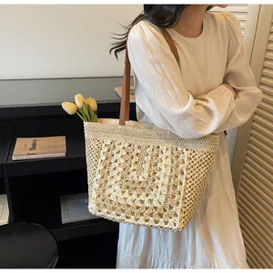Détail du sac cabas en crochet crème avec motifs ajourés et lanières en cuir marron
