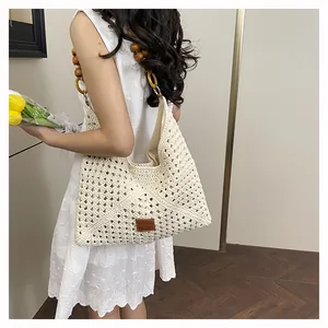 Détail du sac cabas beige tissé à la main avec bandoulière en perles de bois