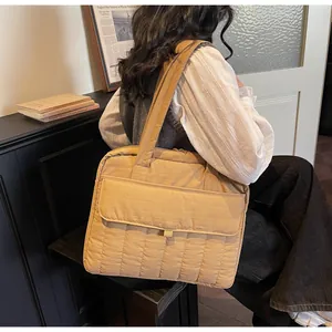 Detalle de bolso acolchado para portátil con rayas verticales y bolsillo con solapa