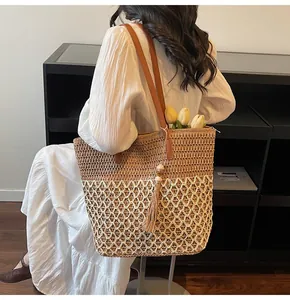 Détail du sac cabas tissé avec anses en cuir marron et pompon décoratif en perles