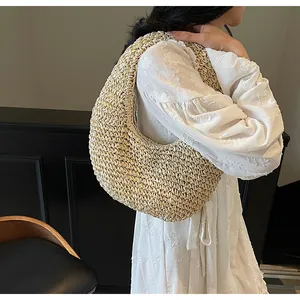 Detailed texture of bohemian straw hobo bag with beige hollow weave and crescent shape