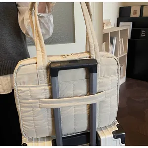 Bolso acolchado beige para portátil con banda para trolley en maleta blanca