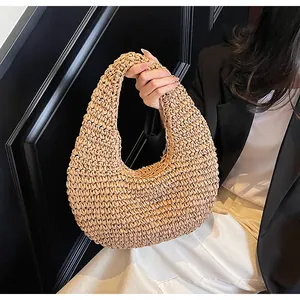 Detailed close-up of the intricate hand-woven straw texture on this chic hobo beach bag