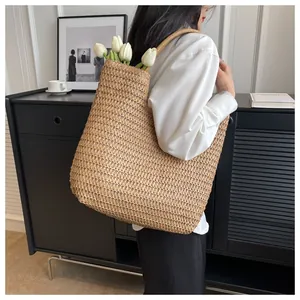 Gros plan sur un grand sac cabas en paille kaki avec une texture en maille épurée