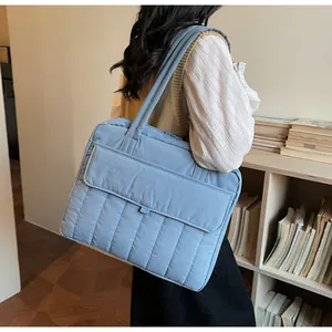 Detalle de la funda acolchada gris azulada para portátil usada por una modelo