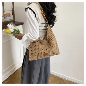 Détail du sac cabas en maille tressée avec bandoulière en perles de bois marron