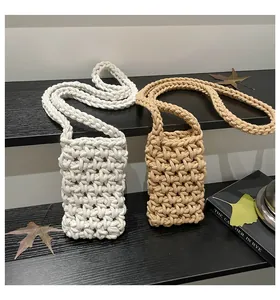 Macro detail of hand-woven cotton texture on mini crossbody bags in white and khaki colors