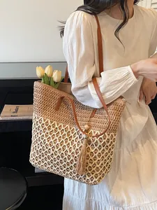 Sac fourre-tout tissé bicolore avec poignées en cuir marron et détail de pompon décoratif