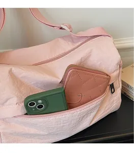 Pink travel tote featuring convenient side pockets for phone and quilted wallet storage