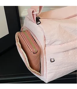 Detailed view of the pink travel bag side pocket holding a long quilted wallet inside