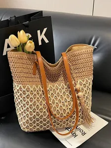 Sac fourre-tout tressé contrasté avec motif ajouré et pompon sur un canapé noir