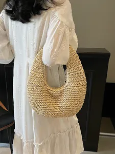 Minimalist beige woven straw hobo bag for beach vacations with natural fiber texture