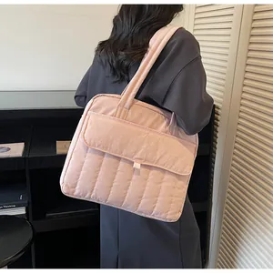 Vista posterior del bolso acolchado rosa para portátil con bolsillo frontal en el hombro de modelo