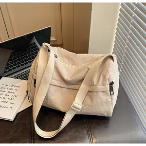 Détail d'un sac cabas en nylon beige avec bandoulière réglable dans un décor de bureau