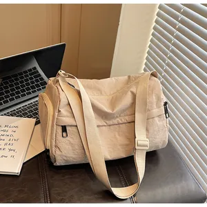 Gros plan détaillé d'un sac bandoulière en nylon beige avec fermetures et sangle réglable