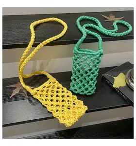 Detail of hollow woven cotton mini crossbody bags in bright yellow and green colors