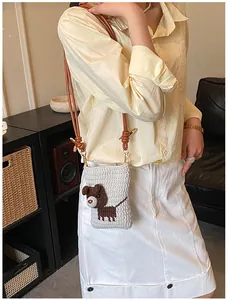 Detail van gehaakte crossbodytas met schattig bruin cartoon puppy-patroon erop geborduurd