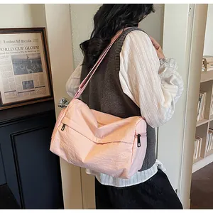 Détail du sac bandoulière rose en nylon avec poches zippées et sangle réglable