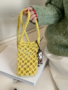 Hollow out cotton woven crossbody bag in bright yellow with cute cartoon girl pendant