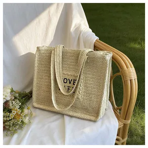 Detail of the woven straw tote bag featuring the LOVE LIFE text and natural fiber texture