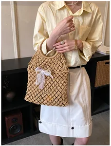 Détail de la texture tisée de ce sac de plage avec poignée ronde en bois et dentelle