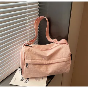 Détail du sac fourre-tout en nylon plissé rose clair avec zips et large bandoulière