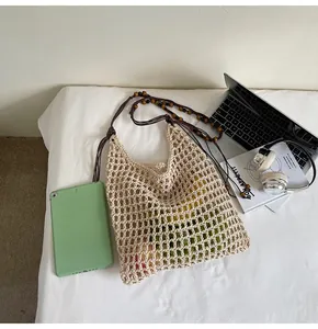 Detail of hollow straw tote bag featuring mesh texture and wooden bead shoulder straps