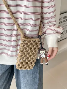 Hollow out cotton woven crossbody bag in natural color with cute cartoon charm