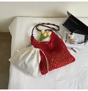 Red hollow-out straw woven tote bag with wooden bead strap and beige inner drawstring pouch