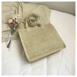 Detailed top view of a large beige straw beach tote bag with a woven texture finish