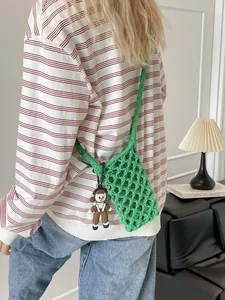 Green hollow crochet crossbody beach bag with a cute cartoon doll pendant charm