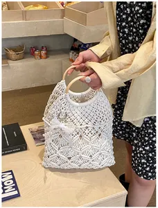 Détail du sac en macramé avec poignée ronde en bois et breloque perle dentelle