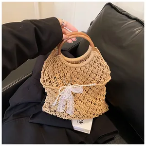 Détail du sac de plage en paille tissé main avec poignée bois, nœud en dentelle et perles