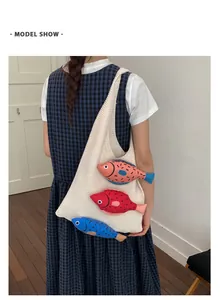 Détail du sac cabas en tricot avec trois poissons en peluche 3D et texture en coton doux