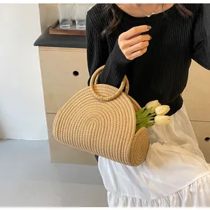 Detailed view of woven straw beach bag with circular handles and spiral texture