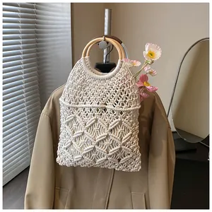 Détail du sac beige tissé à la main avec motif de losanges et poignées rondes en bois