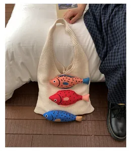Détail du sac cabas en tricot blanc cassé avec des accents de poissons en peluche colorés