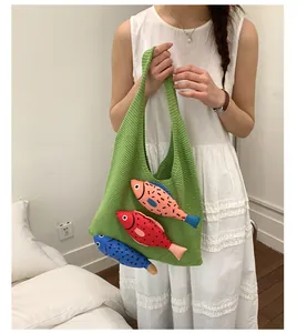 Détail du sac cabas tricoté vert avec trois breloques poissons colorées en 3D