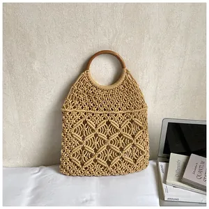Détail du sac cabas bohème tissé avec poignées rondes en bois et texture beige ajourée