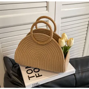 Detail einer Stroh-Handtasche mit runden Griffen und spiraliger Webtechnik