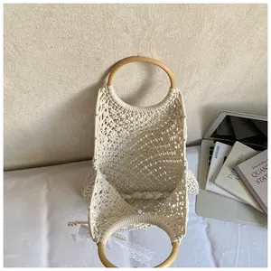 Détail du cabas en maille tissée main avec anses en bois, perles et ruban dentelle