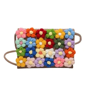 Handwoven crossbody bag with colorful crochet floral patterns on a white background
