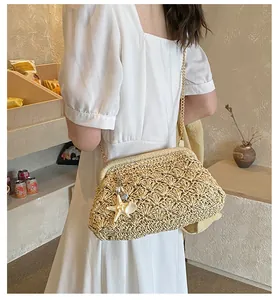 Detail of woven straw bag showing shell pendants and gold chain strap in a cafe setting